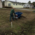 A fertilizer is being spread over a yard