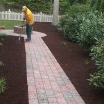 A person taking care of the newly placed mulch
