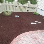 A yard with new red and brown mulch