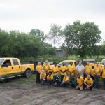 A group photo of 17 people and the vehicles of Royal Lawn Care & Landscaping