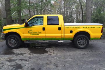 A yellow Royal Lawn Care truck parked at a residence