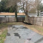 A yard with dead grass around a driveway