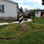 A model lighthouse sits in the middle of an uncared for island garden